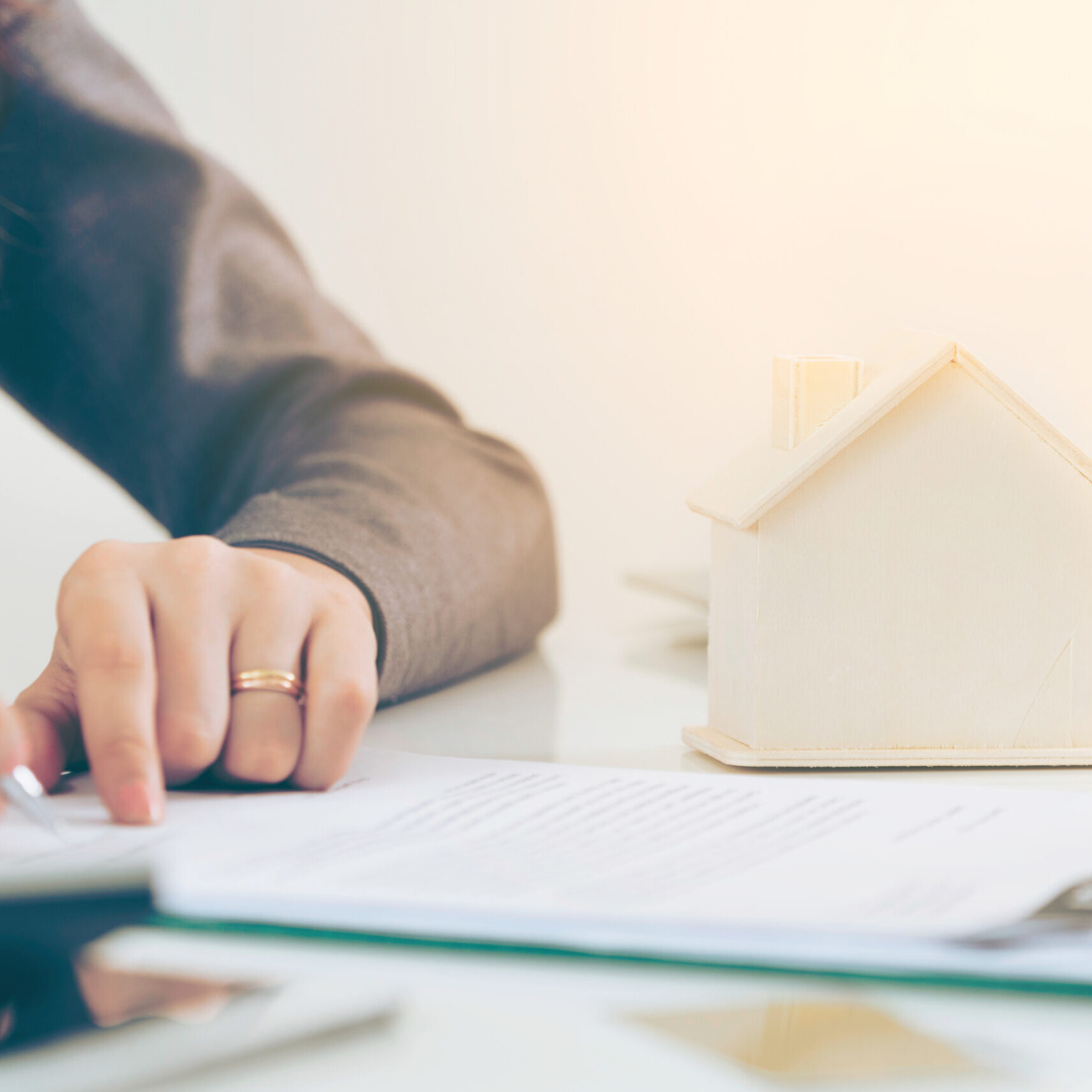 Client signs document regarding real estate activity next to lawyer or real estate agent sitting at office desk. Business concept of selling and buying house.